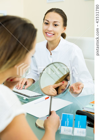Smiling female visitor listening beautician 43531780