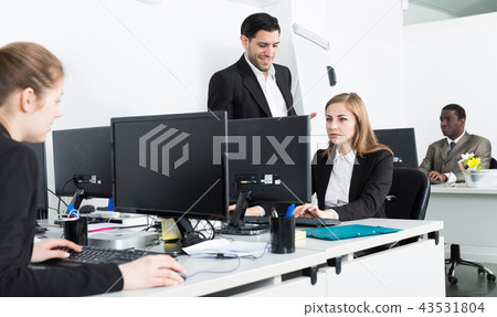 Woman manager working at laptop and man helping 43531804