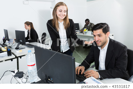 Adult girl helping male colleague in work 43531817