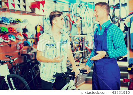 seller and teenager boy customer in bike store. 43531910