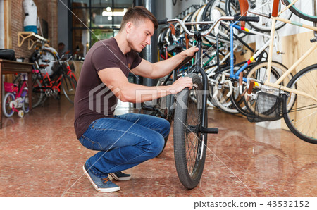 Male is shopping and choosing new bicycle Male is shopping and choosing new bicycle 43532152