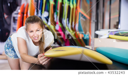 Portrait of positive female who is choosing surfboard Portrait of positive female who is choosing surfboard 43532243