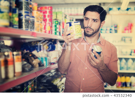 Man is choosing canned peas Man is choosing canned peas 43532340