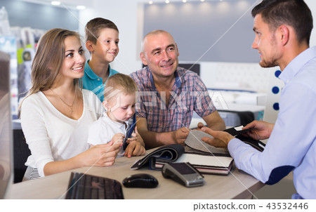 Cheerful family of four are choosing fabric for upholstery mattr Cheerful family of four are choosing fabric for upholstery mattr 43532446
