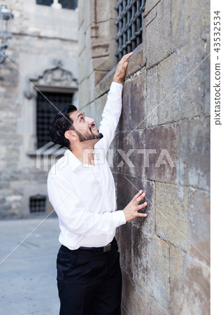 Man trying to climb stone wall Man trying to climb stone wall 43532534