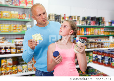 calm father doing shopping with preteen girl in supermarket 43532584