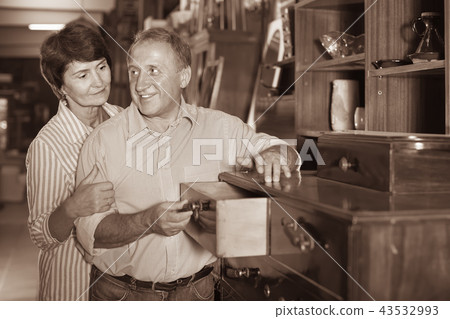 Smiling adult woman with her husband are buying antique curbstone in store 43532993