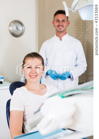 Young female client is sitting satisfied in chair after treatment Young female client is sitting satisfied in chair after treatment 43533069