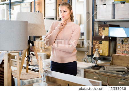 woman buyer standing in furniture shop choosing modern torchere indoors woman buyer standing in furniture shop choosing modern torchere indoors 43533086