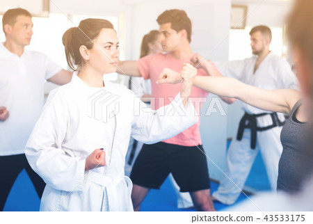 Young men and women are practicing new karate moves in pairs Young men and women are practicing new karate moves in pairs 43533175