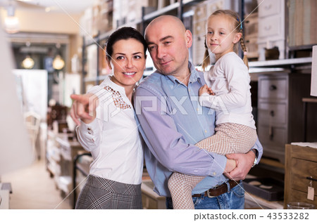 man and woman with child is choosing furniture man and woman with child is choosing furniture 43533282