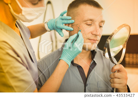 Female doctor is preparing patient for procedure with using marker Female doctor is preparing patient for procedure with using marker 43533427