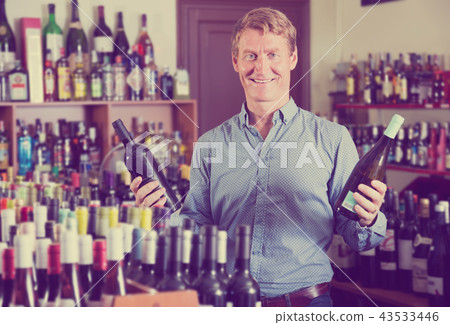 happy man customer buying bottle of wine 43533446