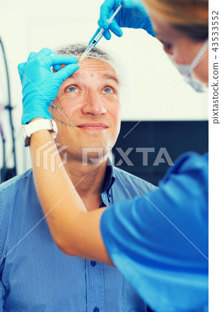 Female doctor is doing injection to patient in skin of face Female doctor is doing injection to patient in skin of face 43533552