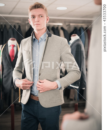 Man purchaser trying jacket in the dress shop Man purchaser trying jacket in the dress shop 43533700