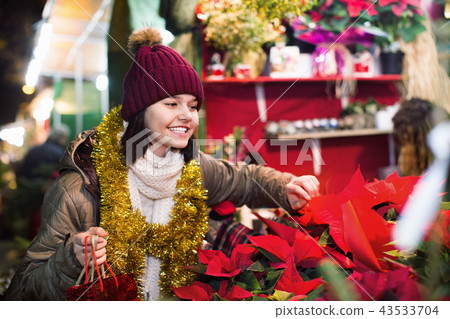Girl buying floral compositions at Christmas market Girl buying floral compositions at Christmas market 43533704