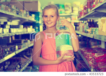 Smiling girl choosing mineral water in bottle 43533723