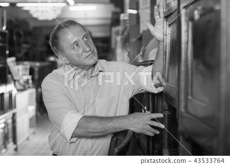 Mature man is shopping the old cupboard 43533764
