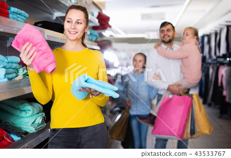 Happy young woman looking for new terry towels during family shopping Happy young woman looking for new terry towels during family shopping 43533767