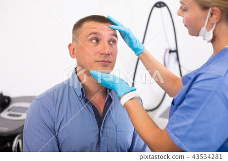 Female specialist is analysing skin of patient before the procedure Female specialist is analysing skin of patient before the procedure 43534281