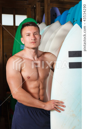 man choosing surf equipment in surf club 43534290