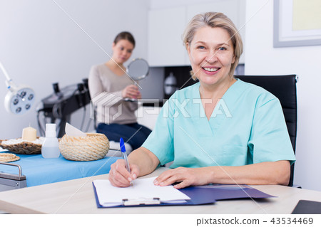 Beautician prescribing procedures to woman Beautician prescribing procedures to woman 43534469
