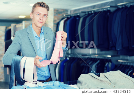 Portrait of man customer choosing tie Portrait of man customer choosing tie 43534515