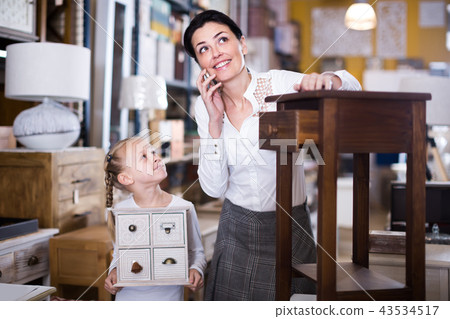 child and her mother are choosing curbstone 43534517