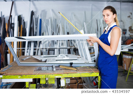 woman using measuring tape in her work in production of pvc windows 43534597