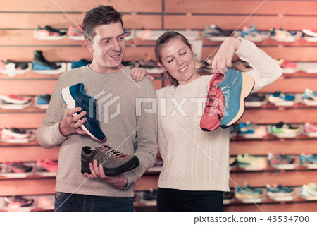Girl and guy choosing clothes and shoes for sports Girl and guy choosing clothes and shoes for sports 43534700