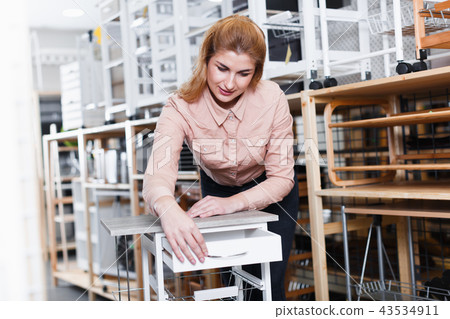 Woman choosing kitchen cabinet in shop Woman choosing kitchen cabinet in shop 43534911