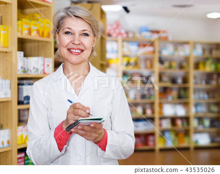Nice female seller checking assortment of care products Nice female seller checking assortment of care products 43535026
