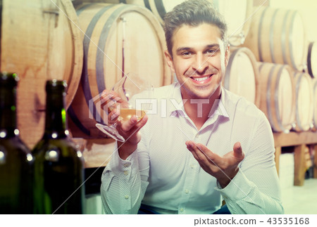 man with glass of brandy in winery store . man with glass of brandy in winery store . 43535168