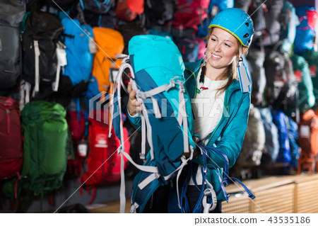 Cheerful girl chooses good backpack in store Cheerful girl chooses good backpack in store 43535186
