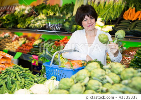 Adult female taking vegetables Adult female taking vegetables 43535335