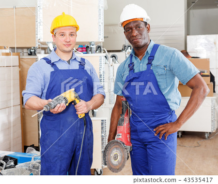 Builders using manual power tools 43535417