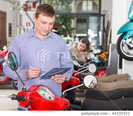 Man is shopping and choosing new motobike Man is shopping and choosing new motobike 43535552