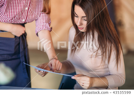 Hospitable waitress help to customer what to choose 43535599