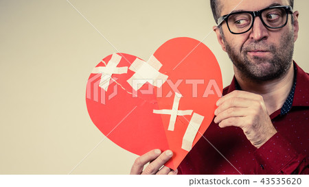 Thinking adult man holding broken heart Thinking adult man holding broken heart 43535620