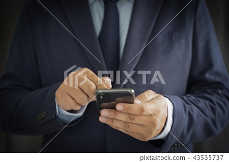 Business man hold the smartphone on the street Business man hold the smartphone on the street 43535737