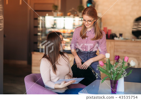 Waitress taking order from her customer in a cafe Waitress taking order from her customer in a cafe 43535754