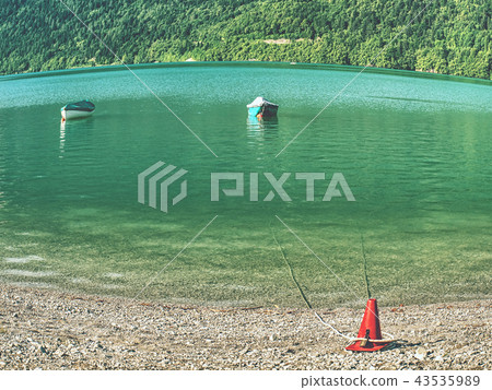 Boat on  green blue water level of Alps lake.  43535989