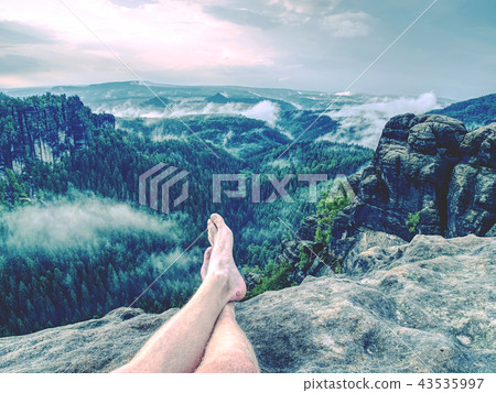 Crossed legs take a rest on mountain trail Crossed legs take a rest on mountain trail 43535997