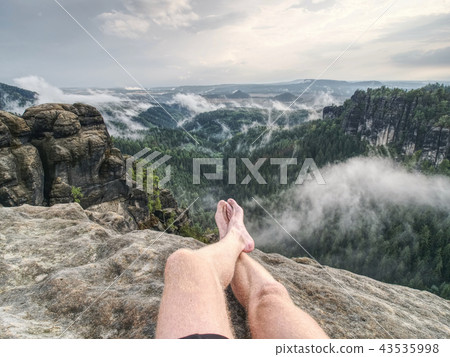 Rock with tired hikers legs without shoes 43535998