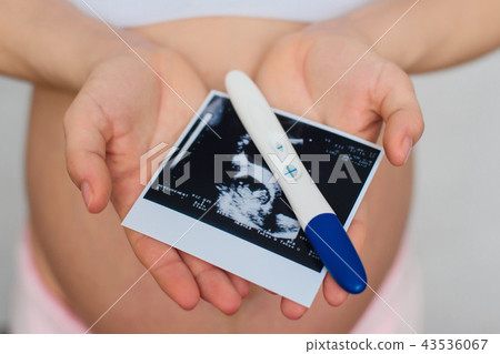ultrasound picture and positive pregnancy test in the hands of a pregnant girl ultrasound picture and positive pregnancy test in the hands of a pregnant girl 43536067