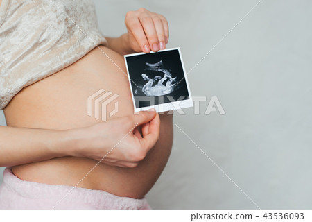 photo ultrasound in the hands of a pregnant girl on a belly background photo ultrasound in the hands of a pregnant girl on a belly background 43536093