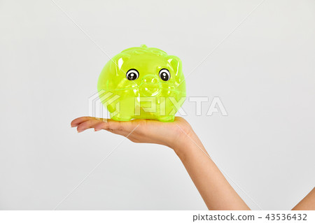 Holding a piggy bank A business woman, holding a piggy bank, 43536432