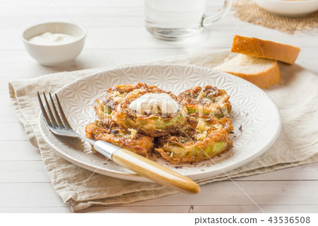 Fried zucchini slices in egg batter with garlic Fried zucchini slices in egg batter with garlic 43536508