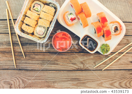 Rolls, wasabi, soy sauce, ginger on table.   43539173