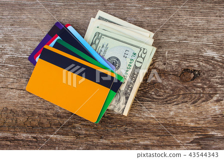 Credit card and dollars on wooden background. Credit card and dollars on wooden background. 43544343